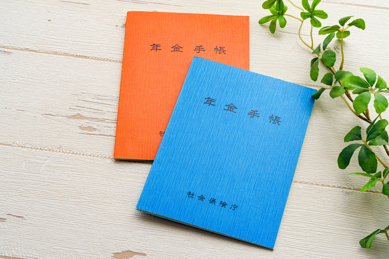 Japanese pension insurance booklet on wooden table. (Written 'pension book')